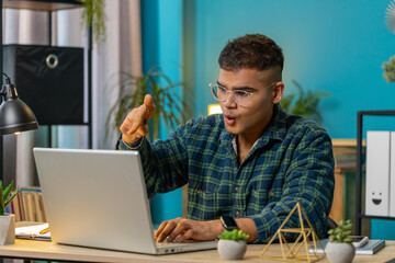Quarrel. Furious annoyed Hindu businessman freelancer engage in heated laptop conversations at home office. Upset boss expresses frustration using cellphone manager guy disputes with subordinates