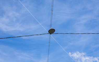 street lamp against blue sky crossed by wires