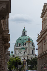 Fototapeta premium А prominent view of the Karlskirche (St. Charles's Church) in Vienna, framed by the facades of surrounding buildings. The church is a masterpiece of High Baroque architecture