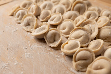 Raw dumplings in flour on the table. Russian national food. Selective focus.