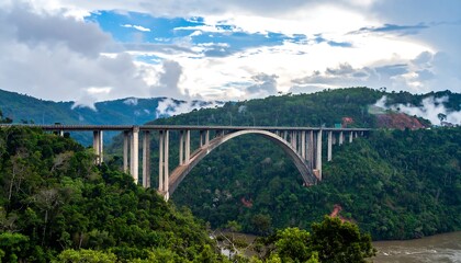 Obraz premium A large arch bridge spanning a valley surrounded by lush green hills.
