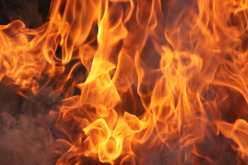 close-up of vibrant, orange and yellow flames, indicating a fire. 