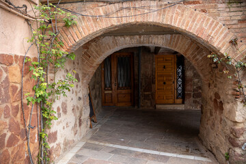 Fototapeta premium Main square of Prades, a charming village in Baix Camp, Tarragona, Catalonia, Spain, known as the “Red Town” for its distinctive reddish sandstone buildings.