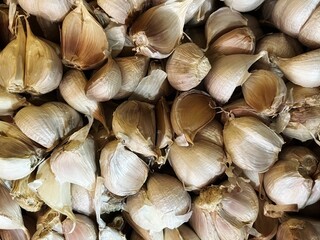 This image shows a pile of garlic bulbs with their garden skins intact. Garlic is a staple spice used globally to enhance the flavor of countless savory dishes.