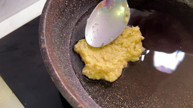 Close-up of zucchini fritter batter mixed with herbs, ready for cooking