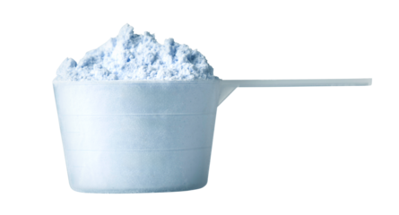 Measuring scoop overflowing with laundry detergent powder on white background