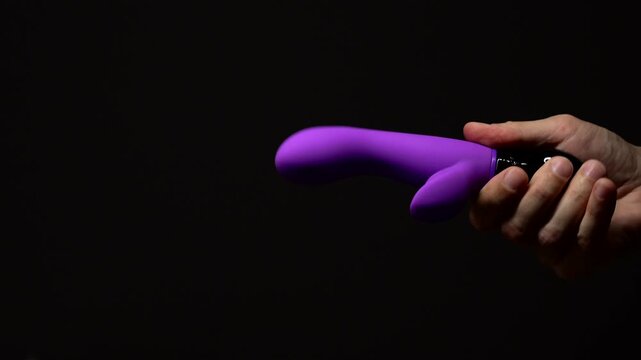 Purple rabbit vibrator for sexual pleasure and enjoyment.
Hand vibrator for orgasm on black isolated background.
Adult sex toys