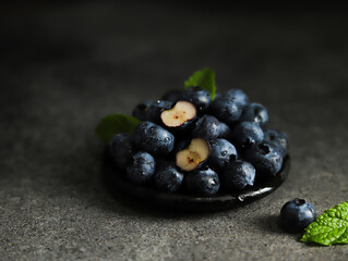 Fresh blueberries with mint and water droplets on dark background