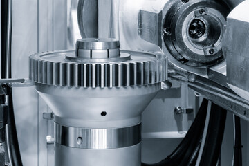 Modern multifunctional CNC metalworking machine with finished round part with gear, industrial concept