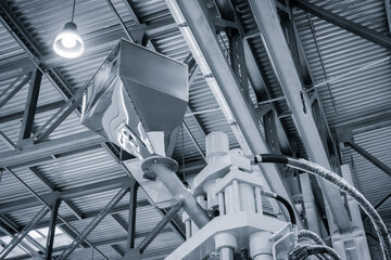 Fototapeta premium Large industrial PVC extrusion machine against industrial metal roof with lighting.