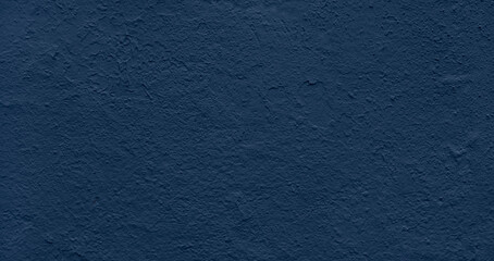 wall in a rich blue hue with a rough, uneven texture as background. It is made of concrete or...