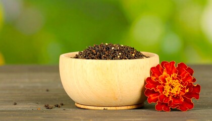 Wooden bowl of loose leaf tea with a marigold flower.