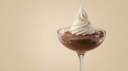 Chocolate mousse dessert topped with a swirl of whipped cream against a soft beige background with copy space.