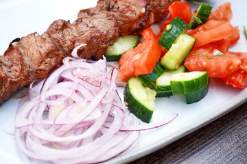 Kebab with tomato and cucumber salad