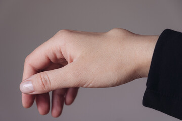 Female right back hand with ganglion cyst on the dorsum,  fluid-filled bump associated with a joint or tendon sheath, close-up view, selected focus.