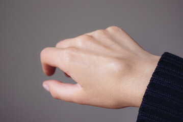 Female right back hand with ganglion cyst on the dorsum,  fluid-filled bump associated with a joint or tendon sheath, close-up view, selected focus.