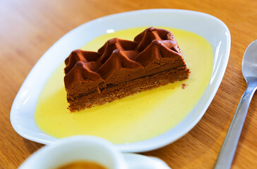 Slice of tasty chocolate cake, sweet dessert with sauce and coffee