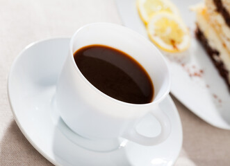 Cup of morning black coffee with piece of cake