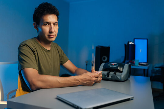 Portrait of cashier organizing currency for automated counting machine during nighttime office shift, processing financial documents under blue ambient lighting. Financial accounting in modern office. - Powered by Adobe