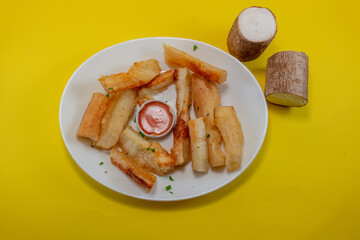 Cassava Fries with Tomato-Mayo Dip and Fresh Cassava Root on Yellow Background