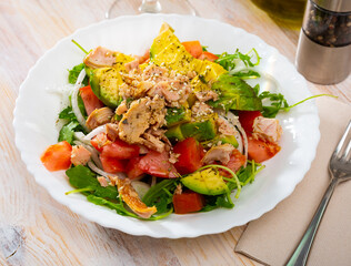 Plate of tasty salad with tuna, corn, tomatoes and arugula