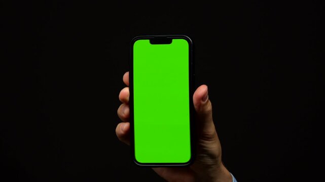 Green screen on mobile phone on isolated black background in male hand.
Replacement of background for commercial use
Smartphone, screen, chromakey, helen, technology