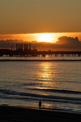 Naklejka premium Sunrise at Platja de la Pineda, Vila-seca, Tarragona, Catalonia, Spain, with views of the port and Tarragona’s cargo cranes over the Mediterranean Sea.