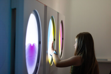 Child interacting with colorful light displays