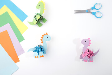 Pinecone dinosaur paper project with sheets and scissors. Great for art educators, craft bloggers, educational publishers, toy stores, and seasonal creative workshops for children,