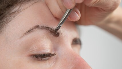 Caucasian woman getting eyebrow tinting procedure. 