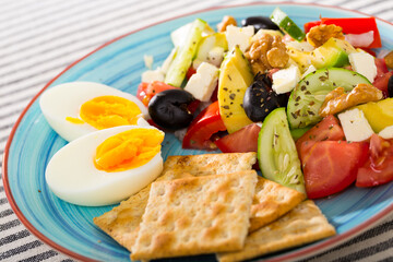 Salad with arugula, olives, Feta cheese, and walnut is tasty dish in the kitchen.