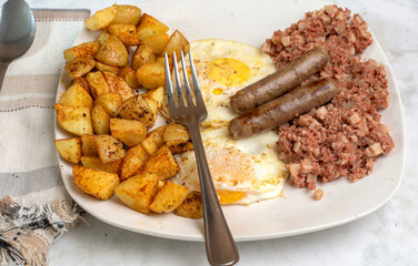 eggs over easy  with corn beef hash and sausages
