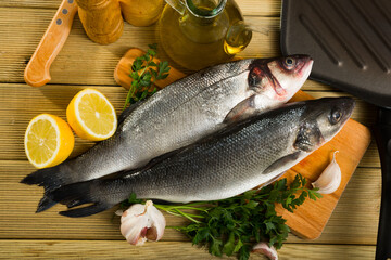 Two fresh raw sea bass fish with parsley, garlic and lemon