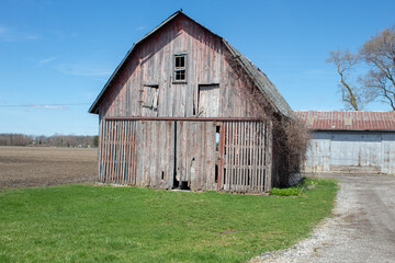 A deteriorated barn next to a corn field. Old barn coming apart. © Romar66