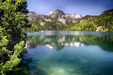 Aerial view of the light snowed mountains and hills during the spring in the Spanish Pyrenees of  Aigues Tortes, Huesca.