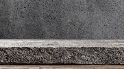 Gray stone slab on a wooden surface against a textured gray wall