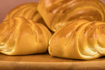 Colorful freshly baked homemade bread rolls on a wooden board with copy space in the foreground
