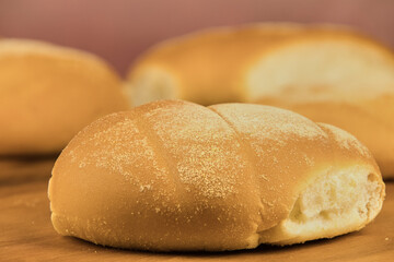 Colorful freshly baked homemade bread rolls on a wooden board with copy space in the foreground