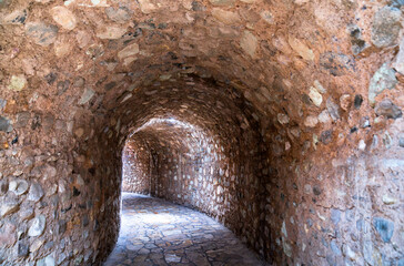 Fototapeta premium Curving stone tunnel with an arched ceiling and paved floor, leading to the Museum of Maya Sculpture at the Copan archaeological site in Honduras
