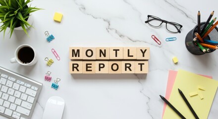 Monthly report workspace flat lay with coffee, stationery, and wooden blocks