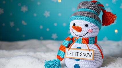 Cute knitted snowman with winter scarf and let it snow sign