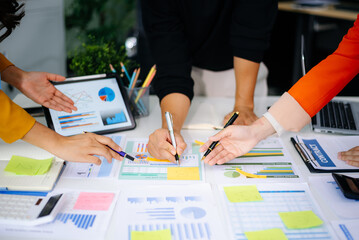 Business team collaboration discussing working analyzing with financial data and marketing growth report graph in team, presentation and digital tablet, laptop