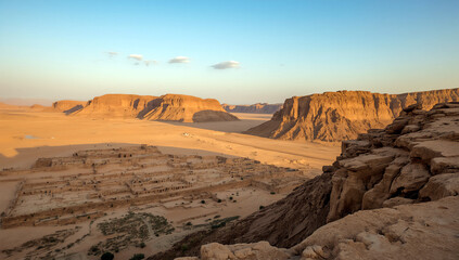 Naklejka premium A scenic desert canyon landscape with rocky cliffs and mountains under a clear sky