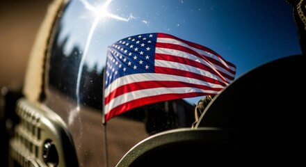 American flag reflected on a vehicle window with bright sunlight and a clear blue sky backdrop scene