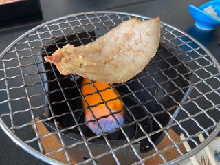Grilling dried fish over charcoal