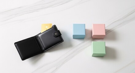 Obraz premium A black leather wallet with a credit card and three pastel colored boxes on a marble surface