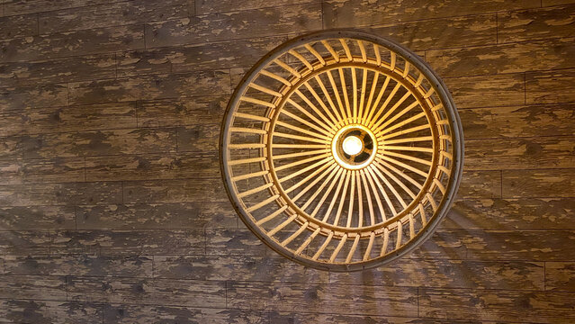 woven bamboo lampshade on the ceiling of a wood-patterned room - Powered by Adobe