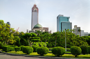 Obraz premium Historic National Taiwan Museum and a modern skyscraper rise above 228 Peace Memorial Park with manicured bushes in Taipei, Taiwan