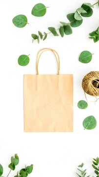 Craft Paper Bag With Green Eucalyptus Leaves And Twine Roll On White Background With Natural Light Minimalist Design Aesthetic