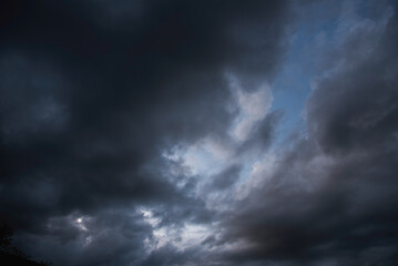 Dark rain cloud dramatic sky summer tropical thunder storm sky and fluffy black darkness cloud nearly raining cloudscape. Nimbus raincloud skyline climate background. Dark gray sky cloudy environment